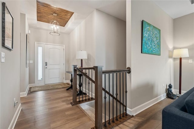 9504 N Amoret Ave, Kansas City, MO 64154 - entryway featuring hardwood / wood-style floors, baseboards, a chandelier, and a raised ceiling