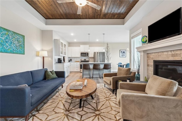 9504 N Amoret Ave, Kansas City, MO 64154 - living room featuring a tray ceiling, light wood-style flooring, wooden ceiling, a ceiling fan, and recessed lighting