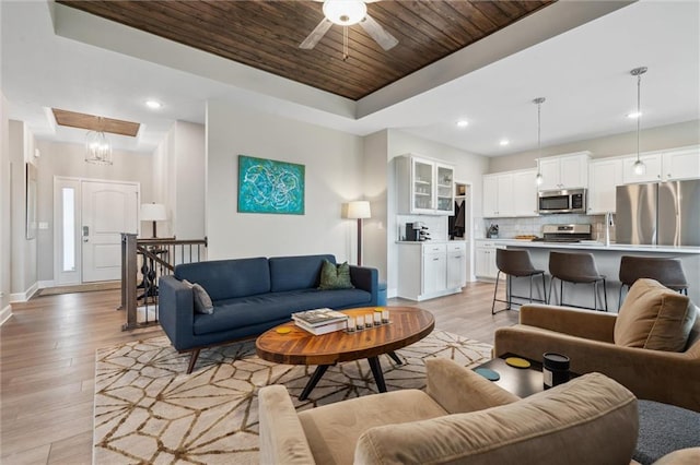 9504 N Amoret Ave, Kansas City, MO 64154 - living room with a raised ceiling, light wood-style flooring, wooden ceiling, baseboards, and a ceiling fan