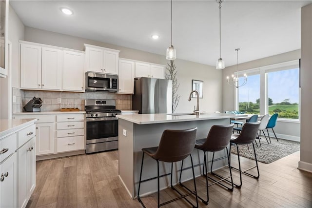 9504 N Amoret Ave, Kansas City, MO 64154 - kitchen with stainless steel appliances, a sink, light wood-style floors, light countertops, and recessed lighting