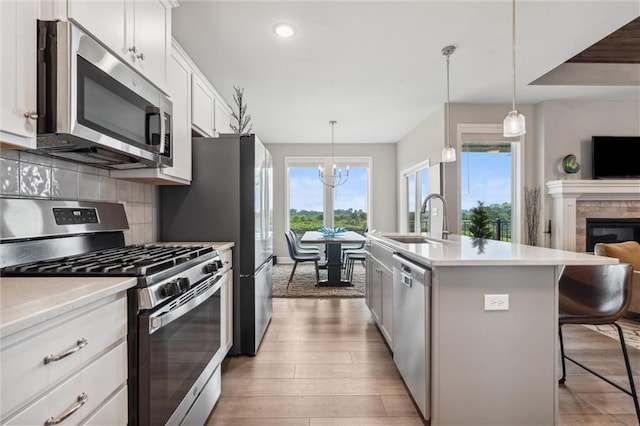 9504 N Amoret Ave, Kansas City, MO 64154 - kitchen with appliances with stainless steel finishes, a sink, plenty of natural light, a kitchen breakfast bar, and recessed lighting