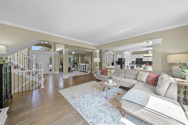 17631 S Brockway St, Olathe, KS 66062 - living area featuring wood finished floors, decorative columns, stairway, ornamental molding, and a textured ceiling