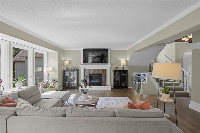 17631 S Brockway St, Olathe, KS 66062 - living room with stairway, dark wood finished floors, a textured ceiling, a tiled fireplace, and ornamental molding