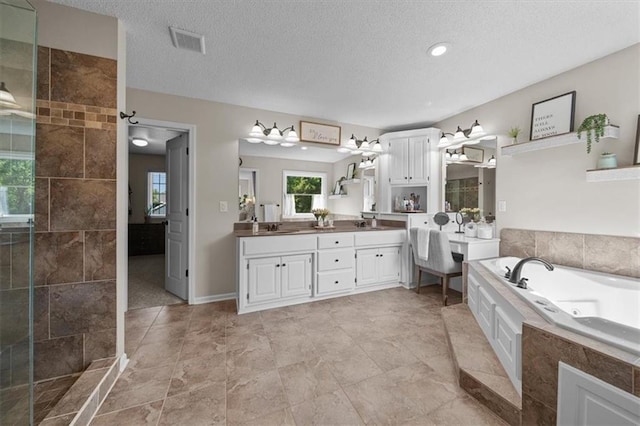 17631 S Brockway St, Olathe, KS 66062 - bathroom with a whirlpool tub, double vanity, a textured ceiling, tiled shower, and recessed lighting