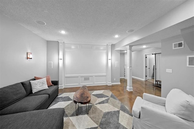 17631 S Brockway St, Olathe, KS 66062 - living room with a textured ceiling, recessed lighting, decorative columns, wood finished floors, and a barn door
