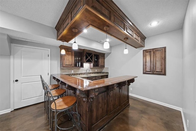 17631 S Brockway St, Olathe, KS 66062 - kitchen featuring decorative backsplash, a textured ceiling, a kitchen breakfast bar, a peninsula, and light countertops
