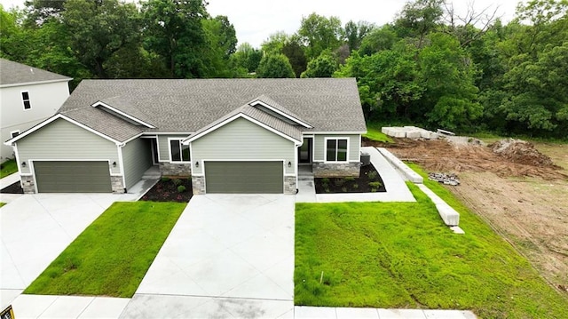 781 Highland Dr, Edwardsville, KS 66111 - view of front of house with stone siding, a shingled roof, a front lawn, and an attached garage