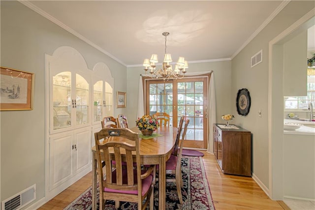 301 W 109th St, Kansas City, MO 64114 - dining space featuring a chandelier, healthy amount of natural light, light wood finished floors, and crown molding