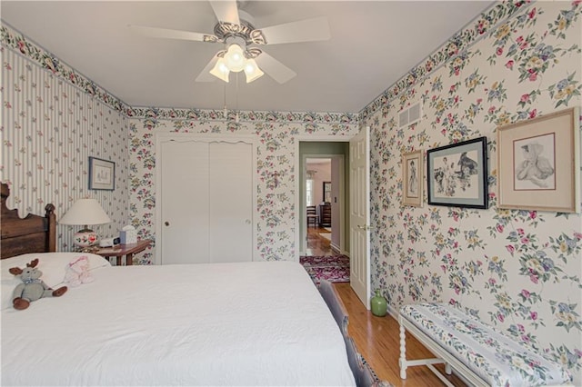 301 W 109th St, Kansas City, MO 64114 - bedroom featuring light wood-type flooring, wallpapered walls, a closet, and ceiling fan