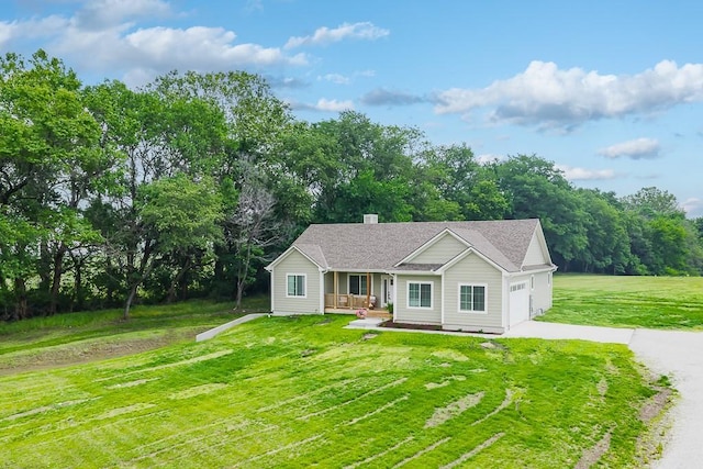 938 Mount Calvary Rd, Lansing, KS 66043 - single story home with concrete driveway, a porch, a front lawn, an attached garage, and view of wooded area