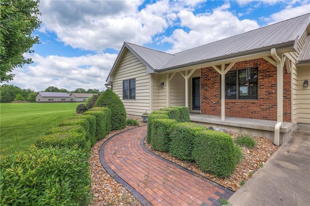 210 SE 200th Rd, Clinton, MO 64735 - view of front of property with a porch, metal roof, a front lawn, and brick siding