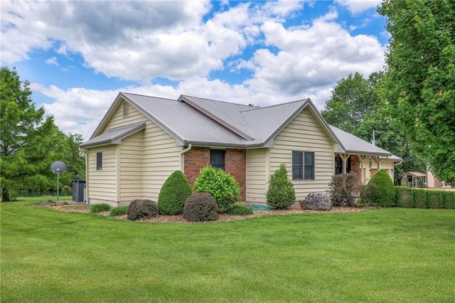 210 SE 200th Rd, Clinton, MO 64735 - view of property exterior with a yard, metal roof, central AC unit, and brick siding