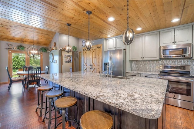 210 SE 200th Rd, Clinton, MO 64735 - kitchen featuring stainless steel appliances, wood ceiling, a sink, light stone counters, and decorative backsplash