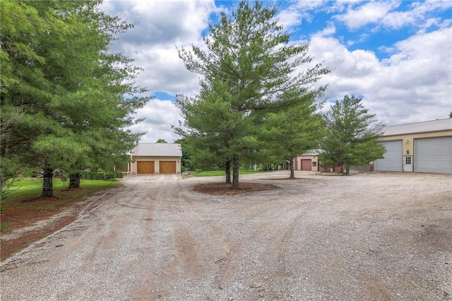 210 SE 200th Rd, Clinton, MO 64735 - view of property hidden behind natural elements featuring a detached garage and dirt driveway