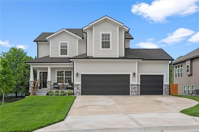 20711 W 49th St, Shawnee, KS 66218 - view of front of property featuring covered porch, a front lawn, concrete driveway, a garage, and central air condition unit