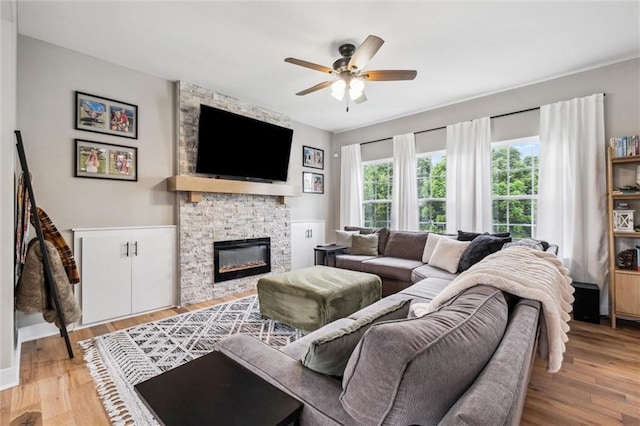20711 W 49th St, Shawnee, KS 66218 - living room featuring a ceiling fan, light wood-type flooring, and a stone fireplace
