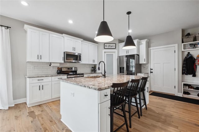 20711 W 49th St, Shawnee, KS 66218 - kitchen with stainless steel appliances, a kitchen breakfast bar, tasteful backsplash, a sink, and white cabinets