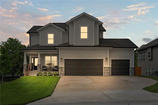 20711 W 49th St, Shawnee, KS 66218 - view of front of house featuring a porch, a lawn, driveway, an attached garage, and stone siding