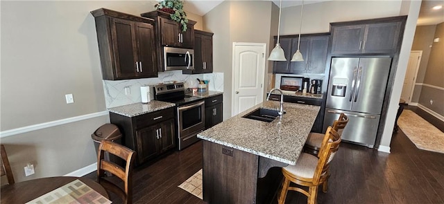 12432 Live Oak Cir, Peculiar, MO 64078 - kitchen with appliances with stainless steel finishes, a sink, decorative backsplash, and light stone counters