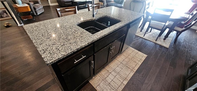 12432 Live Oak Cir, Peculiar, MO 64078 - kitchen with a sink, an island with sink, dark wood-style flooring, light stone counters, and dark cabinetry