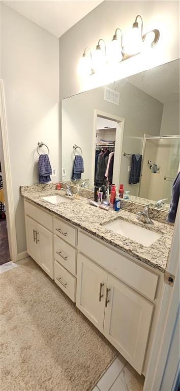 12432 Live Oak Cir, Peculiar, MO 64078 - bathroom with double vanity, a stall shower, and a spacious closet