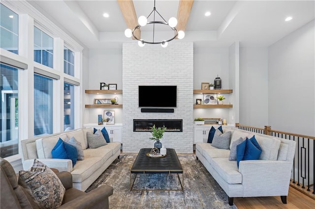 9291 Brownridge St, Lenexa, KS 66220 - living area featuring a chandelier, wood finished floors, a brick fireplace, and beamed ceiling