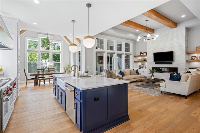 9291 Brownridge St, Lenexa, KS 66220 - kitchen with blue cabinets, stainless steel appliances, beam ceiling, light wood-style floors, and a chandelier
