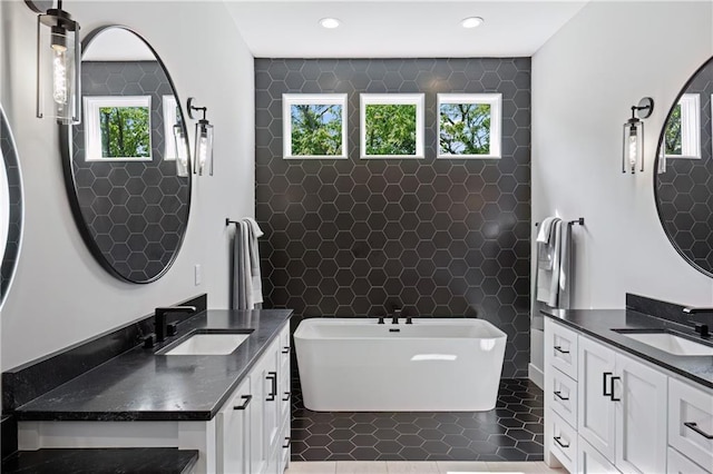 9291 Brownridge St, Lenexa, KS 66220 - full bathroom featuring tile walls, a freestanding bath, two vanities, and recessed lighting