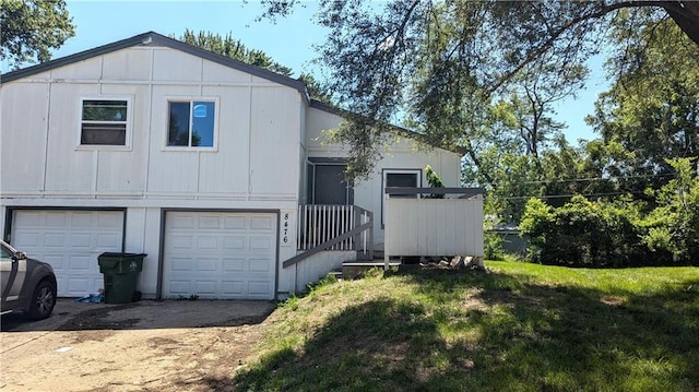8476 Lane Dr, Raytown, MO 64138 - view of front of house with a garage, dirt driveway, a front lawn, and board and batten siding
