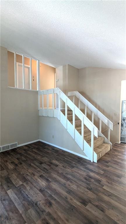8476 Lane Dr, Raytown, MO 64138 - spare room featuring a textured ceiling, wood finished floors, and stairway