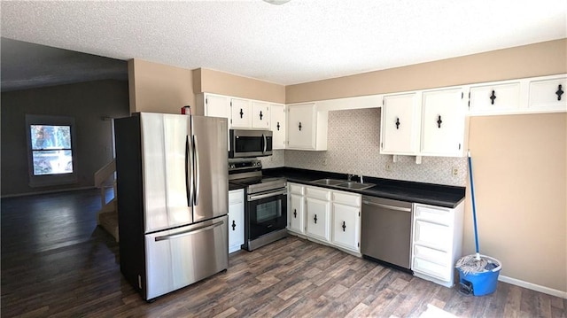 8476 Lane Dr, Raytown, MO 64138 - kitchen with appliances with stainless steel finishes, dark countertops, white cabinetry, dark wood-type flooring, and backsplash