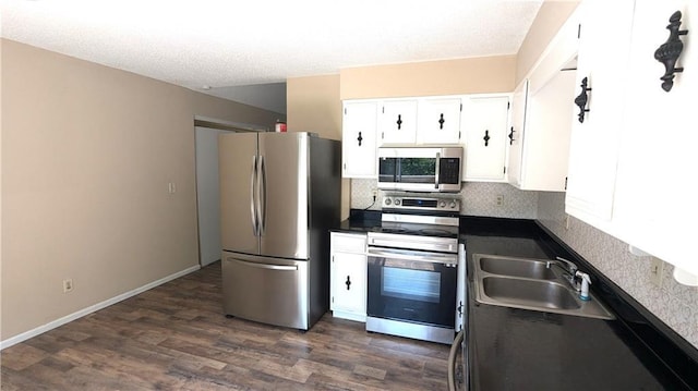 8476 Lane Dr, Raytown, MO 64138 - kitchen featuring stainless steel appliances, dark countertops, backsplash, dark wood-style flooring, and white cabinetry