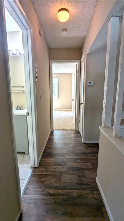 8476 Lane Dr, Raytown, MO 64138 - hallway with a textured ceiling and dark wood-style flooring
