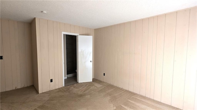 8476 Lane Dr, Raytown, MO 64138 - unfurnished bedroom featuring carpet, wooden walls, and a textured ceiling