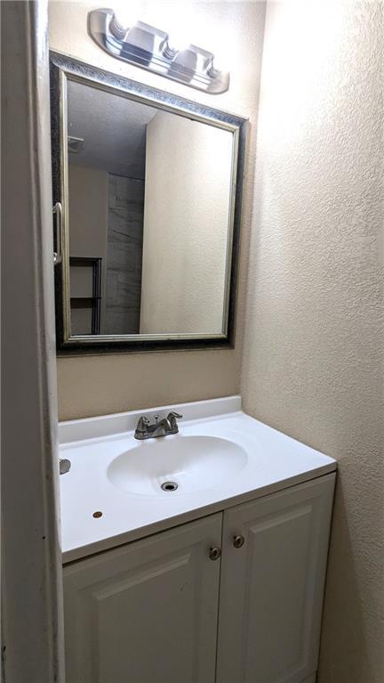 8476 Lane Dr, Raytown, MO 64138 - bathroom with vanity and a textured wall