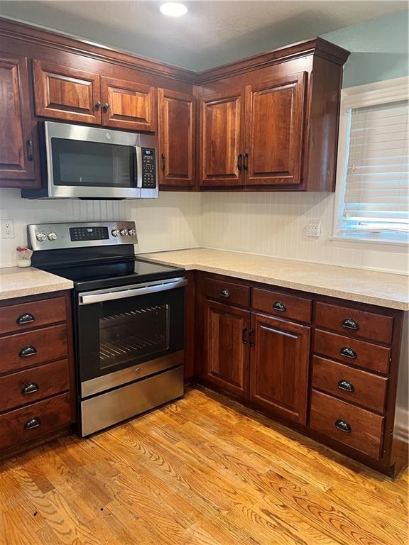 112 Ferrel St, Platte City, MO 64079 - kitchen with stainless steel appliances, light wood finished floors, and light countertops
