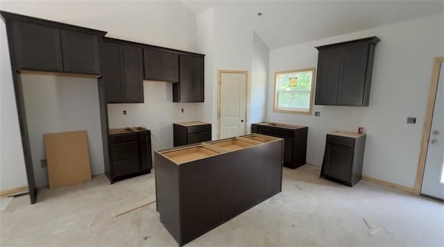 134 Cedar Cir, Warrensburg, MO 64093 - kitchen featuring a center island, light carpet, dark brown cabinets, and high vaulted ceiling