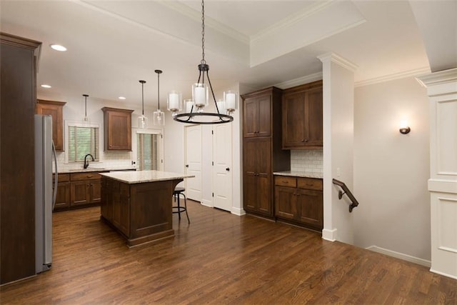 8558 Barstow St, Lenexa, KS 66219 - kitchen featuring freestanding refrigerator, decorative backsplash, dark wood-style floors, a center island, and recessed lighting