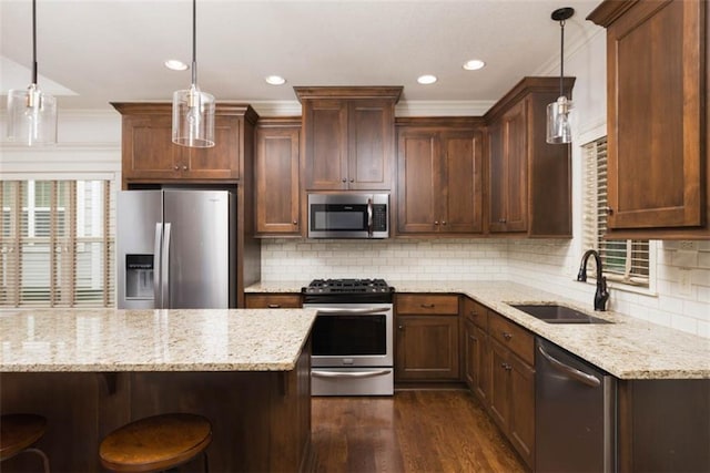 8558 Barstow St, Lenexa, KS 66219 - kitchen featuring stainless steel appliances, dark wood finished floors, light stone countertops, decorative backsplash, and a kitchen bar
