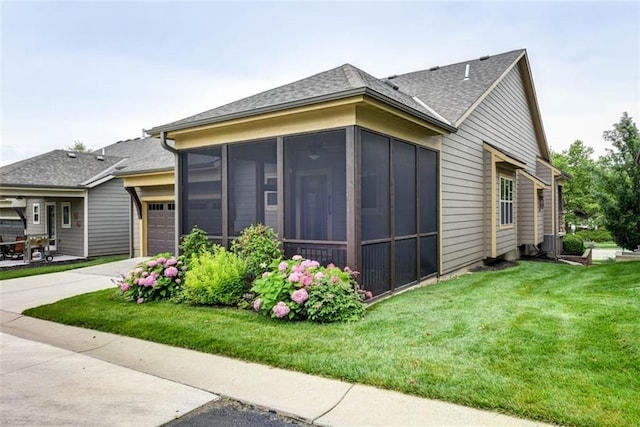 8558 Barstow St, Lenexa, KS 66219 - view of property exterior featuring a garage, concrete driveway, a sunroom, a shingled roof, and a yard