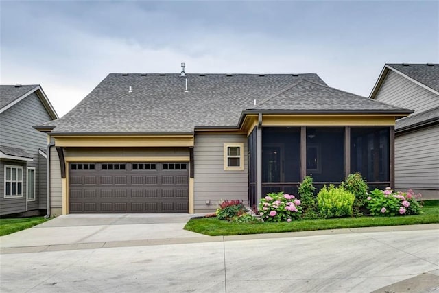 8558 Barstow St, Lenexa, KS 66219 - rear view of house with roof with shingles, a garage, driveway, and a sunroom