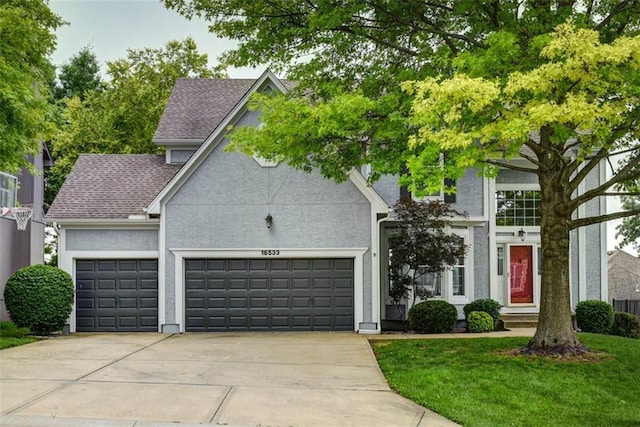 16533 W 80th St, Lenexa, KS 66219 - view of front of house featuring a garage, concrete driveway, a front lawn, stucco siding, and roof with shingles