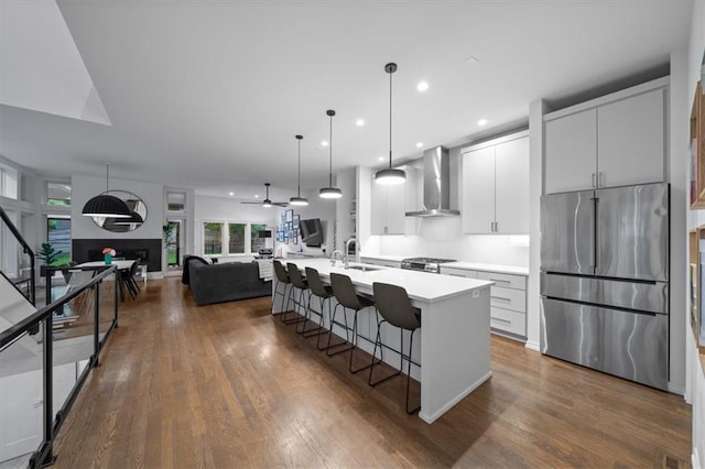 2711 W 49th St, Westwood, KS 66205 - kitchen with stainless steel appliances, wall chimney exhaust hood, a sink, open floor plan, and a kitchen breakfast bar