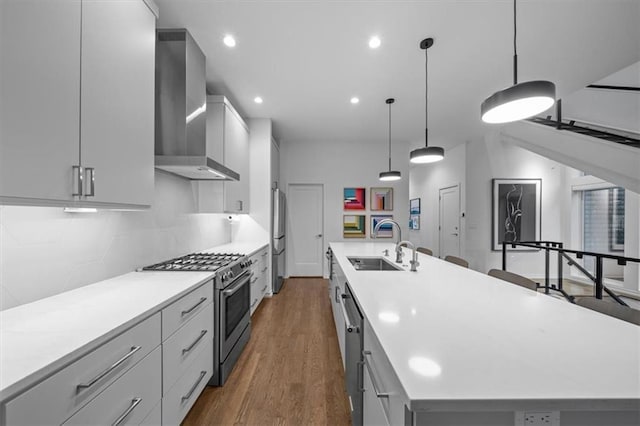 2711 W 49th St, Westwood, KS 66205 - kitchen featuring wall chimney range hood, stainless steel appliances, a sink, a large island, and dark wood-style flooring