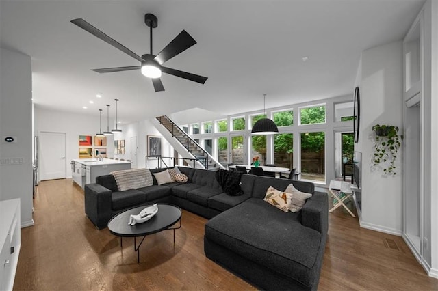 2711 W 49th St, Westwood, KS 66205 - living room featuring stairway, wood finished floors, baseboards, and a ceiling fan