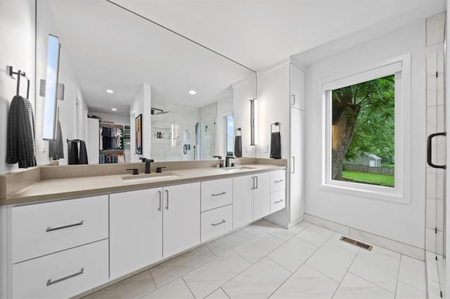 2711 W 49th St, Westwood, KS 66205 - full bathroom featuring double vanity, a stall shower, baseboards, a walk in closet, and tile patterned flooring