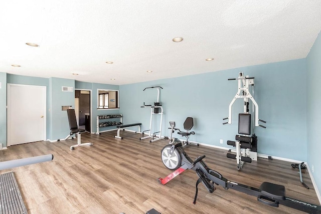 445 W 104th St Unit C, Kansas City, MO 64114 - workout room featuring wood finished floors, baseboards, recessed lighting, and a textured ceiling