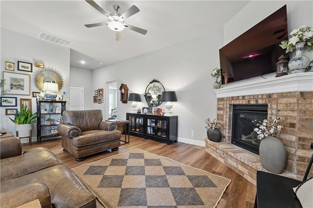 7546 Mccormick Dr, Shawnee, KS 66227 - living room featuring wood finished floors, a ceiling fan, a brick fireplace, and recessed lighting