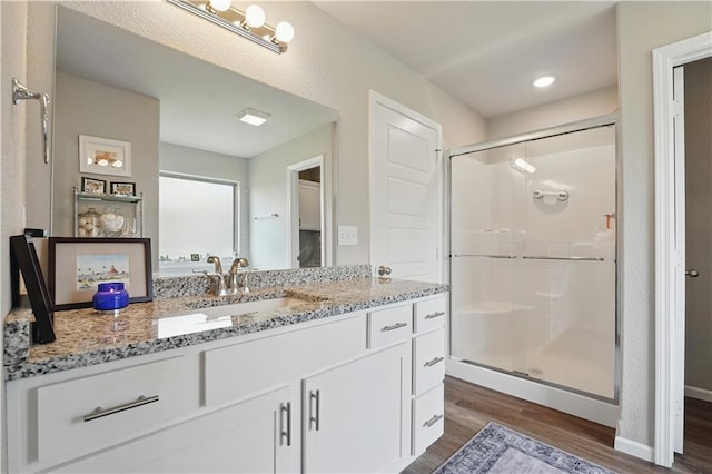 7546 Mccormick Dr, Shawnee, KS 66227 - bathroom featuring wood finished floors, a stall shower, and vanity