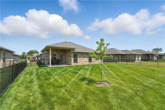 7546 Mccormick Dr, Shawnee, KS 66227 - back of house with a patio area, a fenced backyard, and stone siding